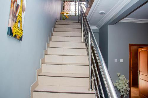 un escalier dans une maison aux murs bleus dans l'établissement Accra cosy homes near beaches and mall, à Accra