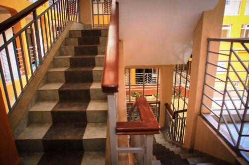 a staircase in a building with a red chair at Todas Hotel in Kiambu