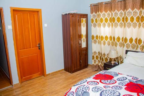 a bedroom with a bed and a wooden door at Accra cosy homes near beaches and mall in Accra