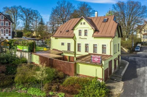 a yellow house with a brown roof at Penzion Pokorny in Jablonec nad Nisou