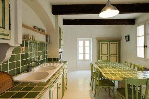 a kitchen with a sink and a table with chairs at Maison de 2 chambres avec piscine partagee terrasse amenagee et wifi a Valaurie in Valaurie
