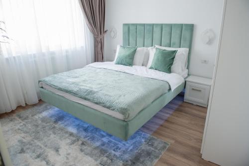 a bed with a green headboard in a bedroom at Cosy retreat in Piatra Neamţ