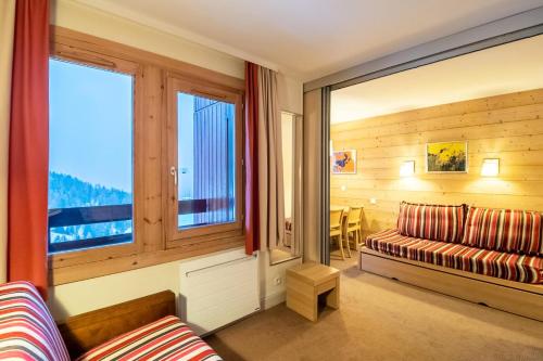 un salon avec un canapé et une grande fenêtre dans l'établissement Résidence Plagne Lauze - maeva Home - Studio 4 personnes - Budget MAE-0934, à Mâcot La Plagne