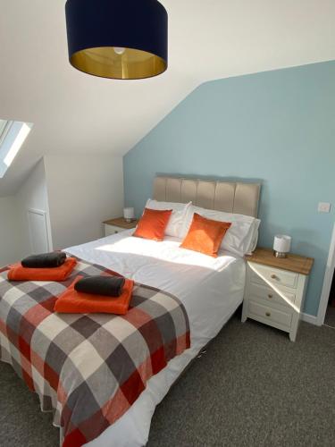 a bedroom with two beds with orange pillows at stylish and modern Spacious 2 bedroom apartment in Clodock