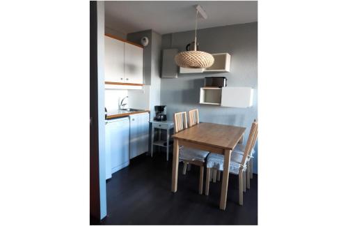 une cuisine et une salle à manger avec une table et des chaises dans l'établissement Résidence Le Hameau du Sauget - maeva Home - Appartement 2 pièces 4 personnes - Budget MAE-0904, à La Plagne Tarentaise
