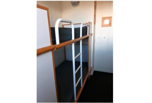 Ce lit superposé se trouve dans un dortoir avec une échelle. dans l'établissement Résidence Le Hameau du Sauget - maeva Home - Appartement 2 pièces 4 personnes - Budget MAE-0904, à La Plagne Tarentaise