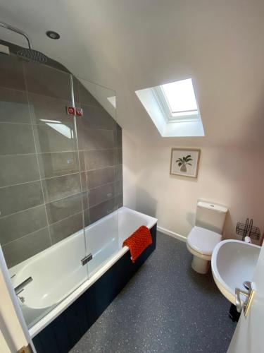 baño con bañera, aseo y tragaluz en stylish and modern Spacious 2 bedroom apartment, en Clodock