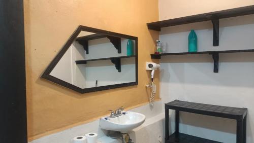 baño con lavabo y espejo en la pared en Casa B&V en Isla Mujeres