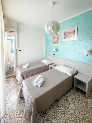 a room with two beds and a bathroom at Hotel Reale in Rimini