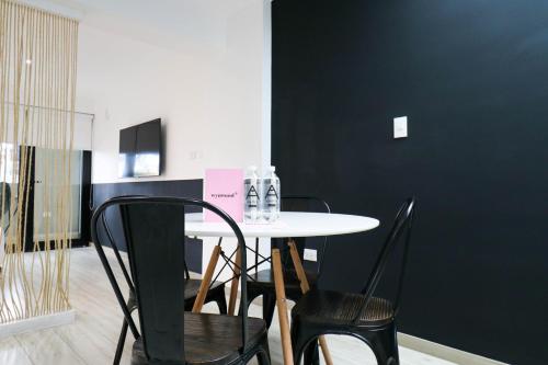 a table and chairs in a room with a black wall at Primera Parada By Wynwood House in Lima