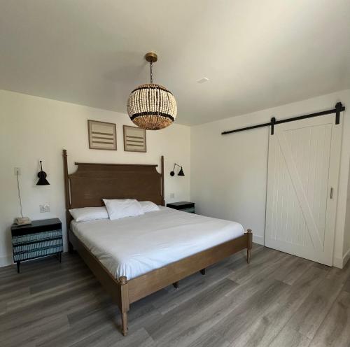 a bedroom with a bed and a chandelier at Anaheim Maingate Inn in Anaheim