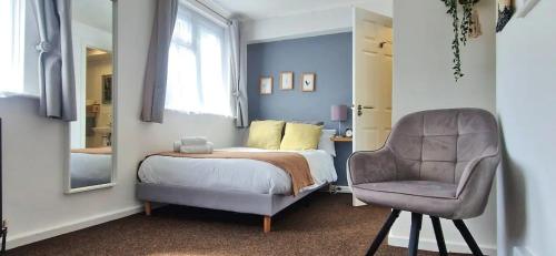 1 dormitorio con cama, silla y espejo en Southampton Lodge, en Southampton