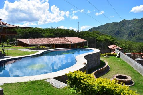 a swimming pool in the yard of a house at Vistabamba Ecuadorian Mountain Hostel in Vilcabamba