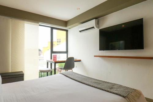 a bedroom with a bed with a flat screen tv at Primera Parada By Wynwood House in Lima