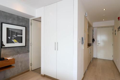 a hallway with white cabinets and a painting on the wall at Primera Parada By Wynwood House in Lima