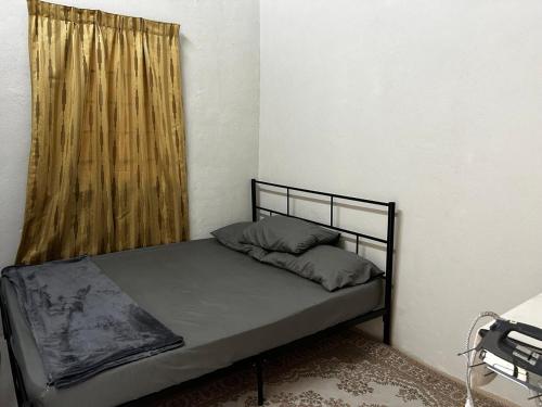 a bed in a small room with a window at Sinar Homestay in Kuala Terengganu