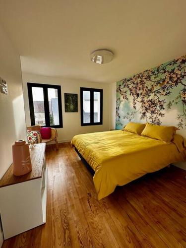 een slaapkamer met een bed met een gele sprei bij Maison de campagne normande in Pitres