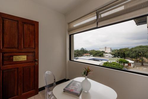 a room with a table and a large window at Parque del Lago Boutique Hotel in San José