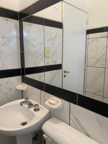 a white bathroom with a sink and a mirror at Urqu-Pacha Alojamiento in Tinogasta