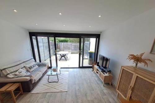 a living room with a couch and a tv at Bright house with terrace and garden in Camiers