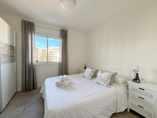 Un dormitorio blanco con una cama con dos animales de peluche. en Clauhomes Suite Center, en Tarragona