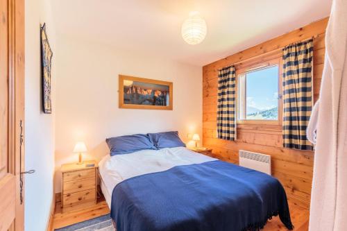 une chambre avec un lit bleu et une fenêtre dans l'établissement Résidence Saint-Bernard - maeva Home - Appartement 2 pièces 6 personnes - Sélection MAE-1754, à Arc 1800