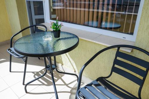 a glass table and a chair on a balcony at Family Hotel Gotse Delchev in Gotse Delchev