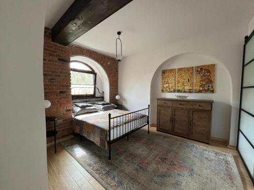 a bedroom with a bed and a brick wall at Loft pod Starym Kasztanem in Krynica Zdrój