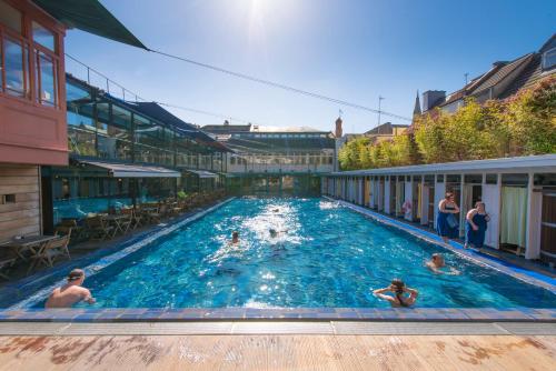 a group of people swimming in a swimming pool at Lido Townhouse in Bristol