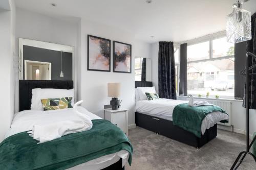 1 dormitorio con 2 camas y ventana en Cosy 2BR Bungalow + Parking, en Northampton