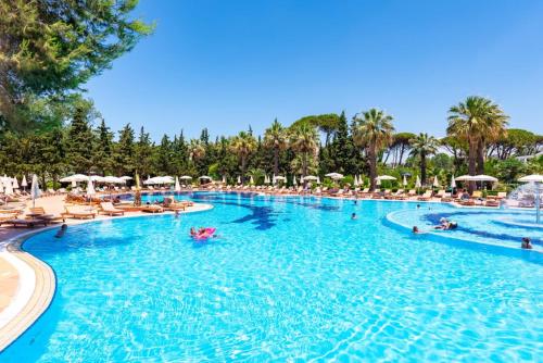 einen Pool in einem Resort mit Leuten darin in der Unterkunft ASHLEY APARTMENTS in Durrës