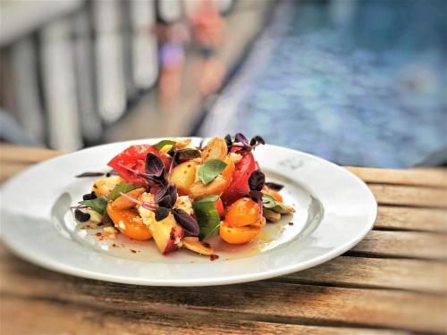 a white plate with a salad on a table at Lido Townhouse in Bristol