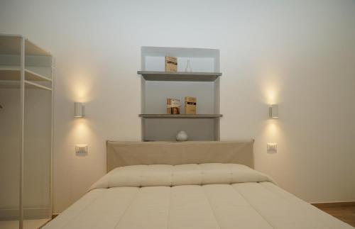 een slaapkamer met een bed met twee lampjes aan de muur bij Les pieds dans l'eau Vernazza in Vernazza