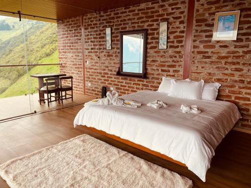 a bedroom with a large bed and a brick wall at Casa de Campo El Descanso in Baños
