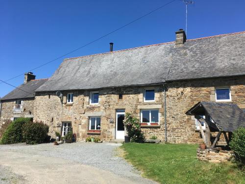une ancienne maison en pierre avec un toit gris dans l'établissement Les Chouettes, à Les Portes du Coglais