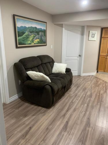 a living room with a brown couch in the corner at 1 room in a cozy and beautiful basement in Guelph
