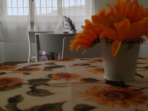 un jarrón de flores naranjas sentado en una mesa en Casa Vacanze La Pineta del Mare, en Torre Ovo