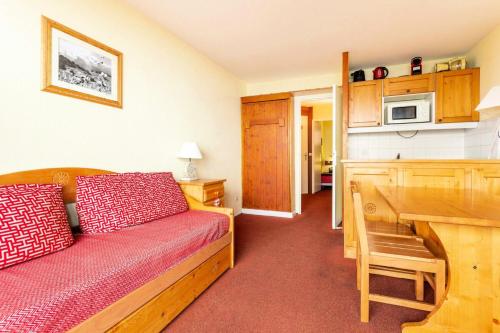 Cette chambre comprend un lit et un bureau avec un four micro-ondes. dans l'établissement Résidences quartier Charmettoger - maeva Home - Appartement 2 pièces 5 personnes - Budget MAE-1884, à Arc 1800