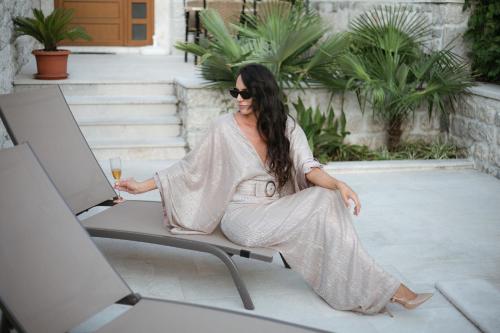 a woman sitting on a chair in front of a laptop at Three Dots by Todorovic Family in Kotor
