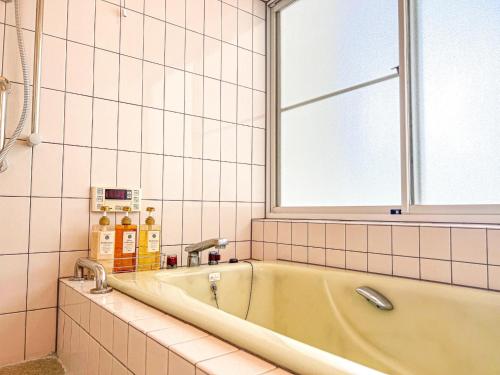 eine Badewanne im Bad mit Fenster in der Unterkunft Nasu Kogen Yamagoya - Vacation STAY 29336v in Shiozawa