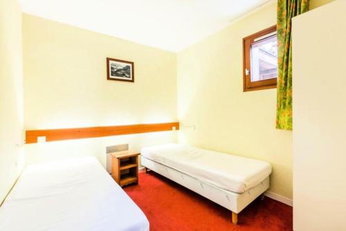 une chambre avec deux lits et une fenêtre dans l'établissement Résidences quartier Charmettoger - maeva Home - Appartement 2 pièces 5 personnes - Budget MAE-2384, à Arc 1800