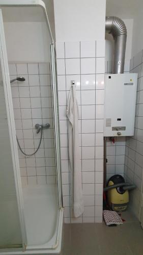 a shower in a bathroom with a white tiled wall at Apartment nahe Cannstatter Wasen und Stadion in Stuttgart