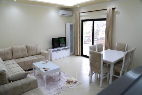 een woonkamer met een bank en een tafel bij Vila Emi in Durrës