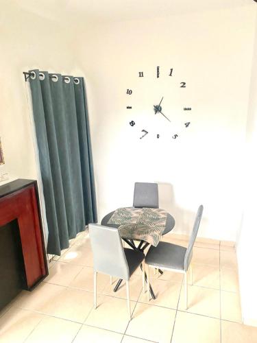 a dining room with a table and a clock on the wall at DAMAS in Douala
