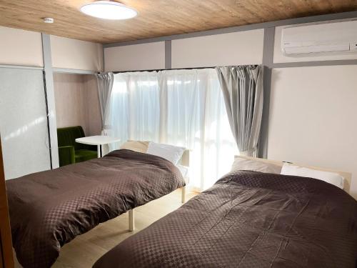 a bedroom with two beds and a window at Izumo no Oyado Naka Araki - Vacation STAY 82773v in Izumo