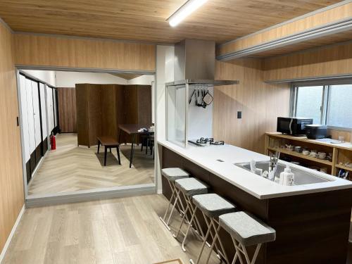 a kitchen with a sink and a counter with stools at Izumo no Oyado Naka Araki - Vacation STAY 82773v in Izumo