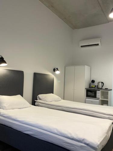 Duas camas num quarto com paredes brancas em Apartment Loftas13-6 em Kretinga