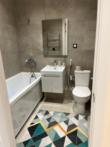 Ömirzaq的住宿－Aktau Reviera 1 ком апартамент，浴室配有盥洗盆、卫生间和浴缸。