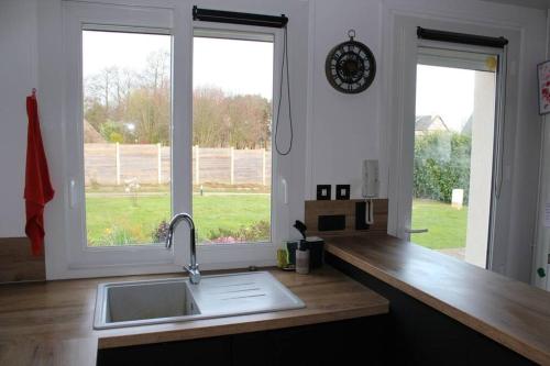 - un comptoir de cuisine avec évier et 2 fenêtres dans l'établissement L’Augustine, maison contemporaine à la campagne !, au Tilleul