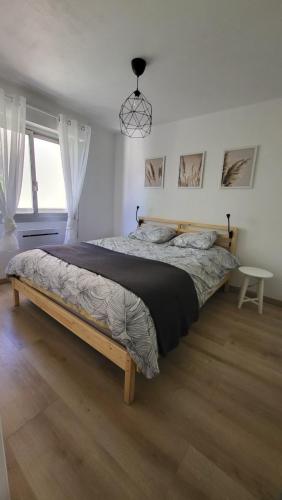 une chambre avec un grand lit dans une pièce dans l'établissement Appartement de 50 m2 cosy et moderne à 100 m de la plage, à Saint-Mandrier-sur-Mer